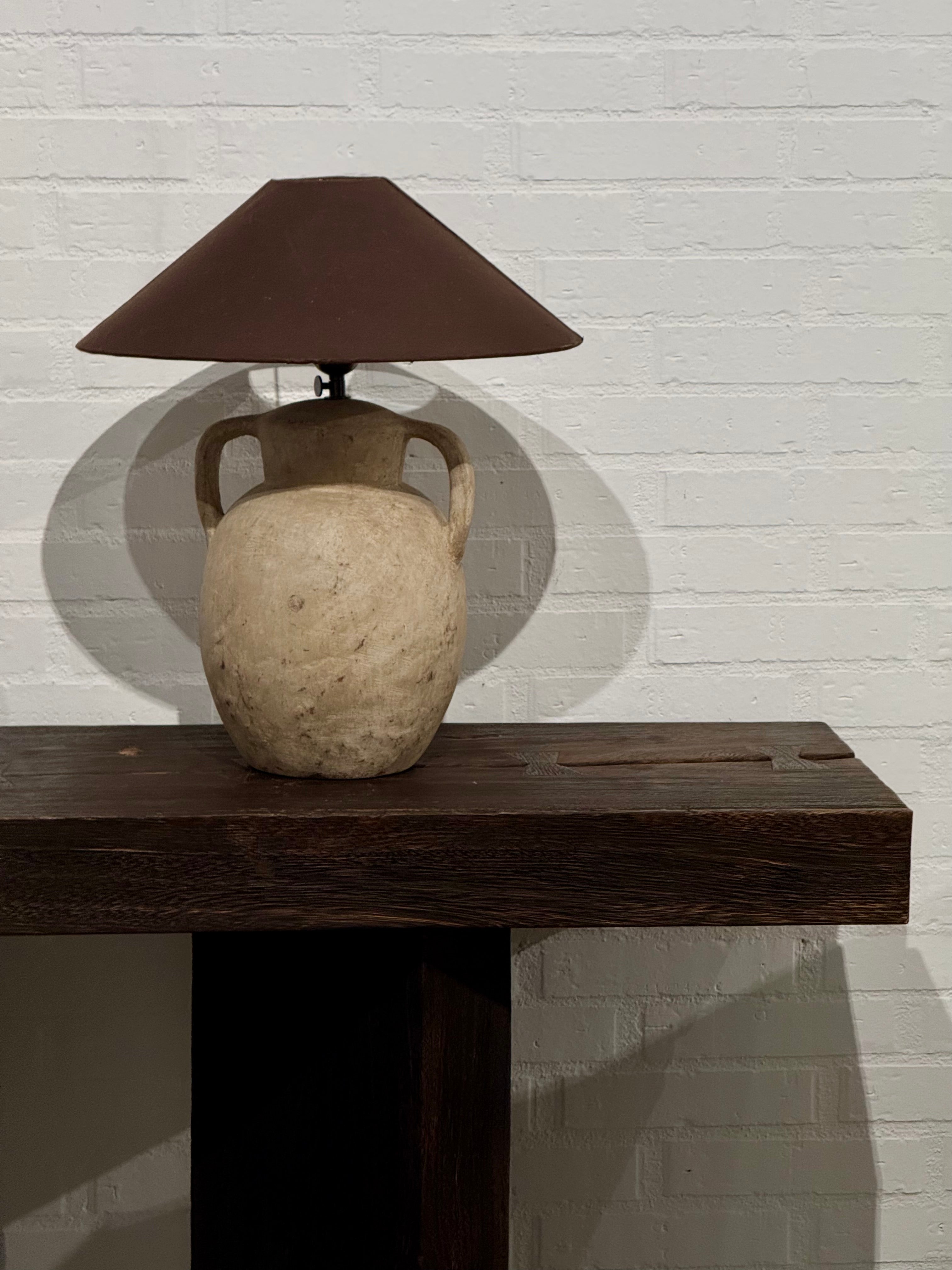 Lámpara de mesa artesanal con base de cerámica envejecida.